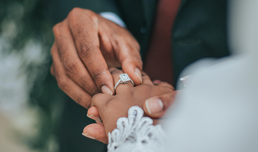 A groom putting a ring on a bride's hand, in the context of a marriage based green card or options for a green card without marriage.