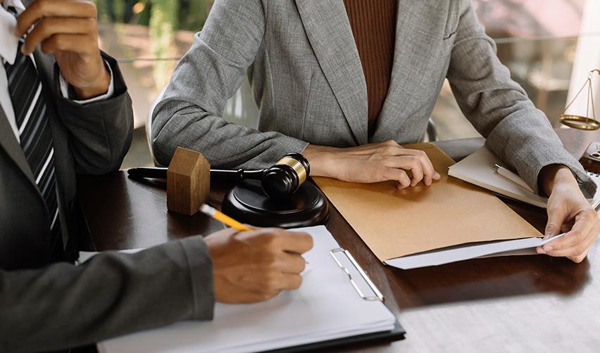 An EB5 investor and an immigration lawyer going over USCIS requirements with documents on a desk.
