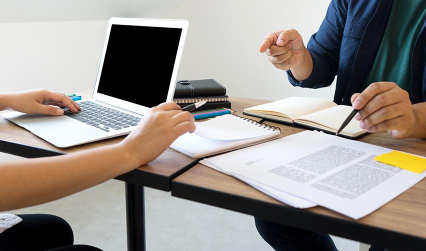 EB-5 regional center applications and associated investor petitions are being reviewed by the USCIS auditing team on a desk with a computer and some documents.