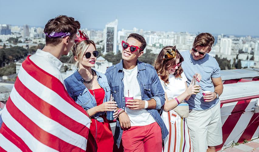 A green card holder group hanging out outdoors dressed in American flags.