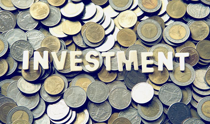 The word investment spelled out on top of a pile of coins.