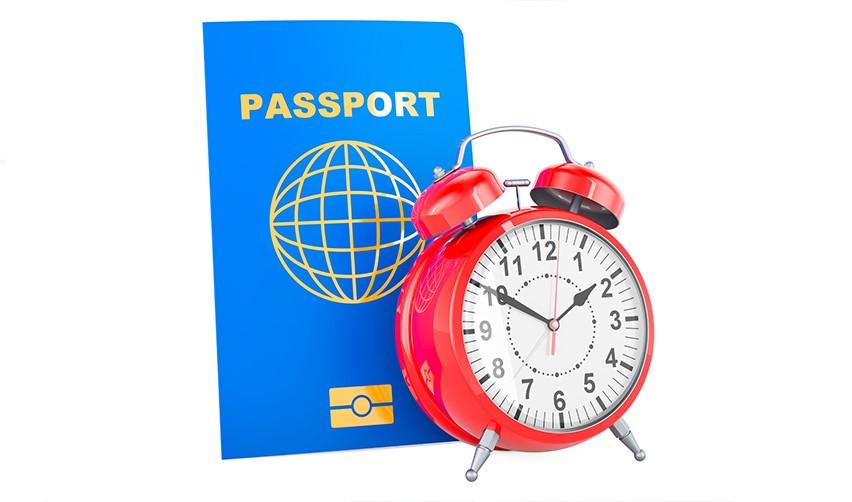 A red alarm clock next to a passport, showing the timeline of the EB-5 visa process from conditional permanent residence to U.S. citizenship.