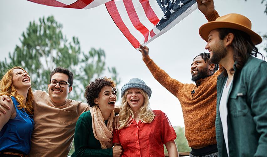 A group of EB5 investors having fun outside and holding up the U.S. flag.