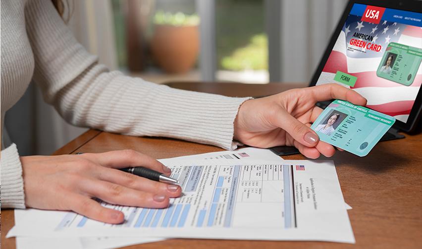 A foreign investor filling out Green Card forms on a table.