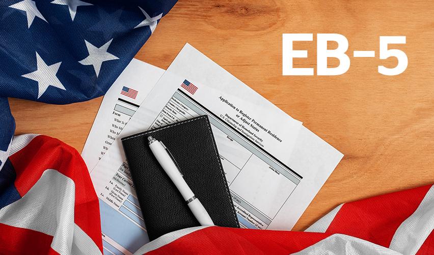 Two forms on a desk with the word EB-5 on the corner, visualizing how immigrant investors can change their nonimmigrant status and register permanent residence.