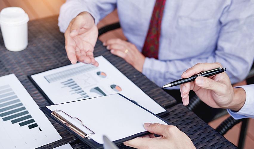 An EB5 investor examining some offering documents or required documentation with the help of an immigration attorney or a member of a regional centers management team.
