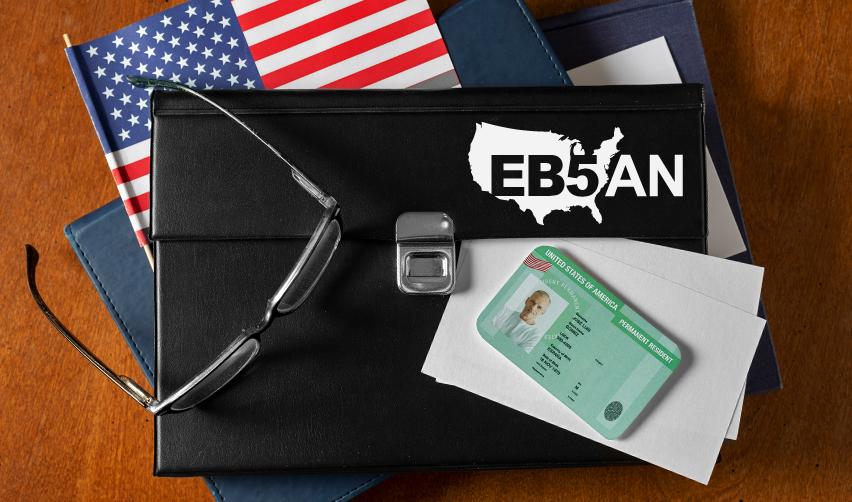 A black briefcase with glasses, an American flag, and a green card on top, with the EB5AN logo on it.