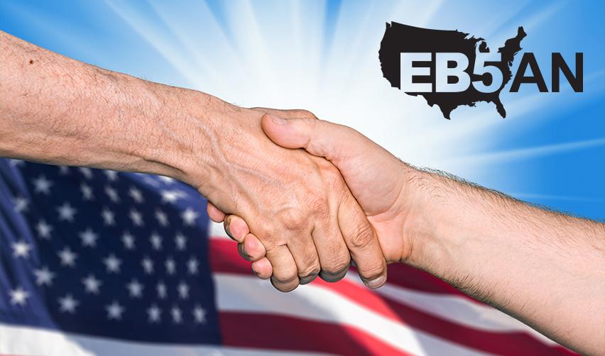 An immigration attorney and immigrant petition applicant shaking hands in front of the American flag, with the EB5AN logo on the corner.