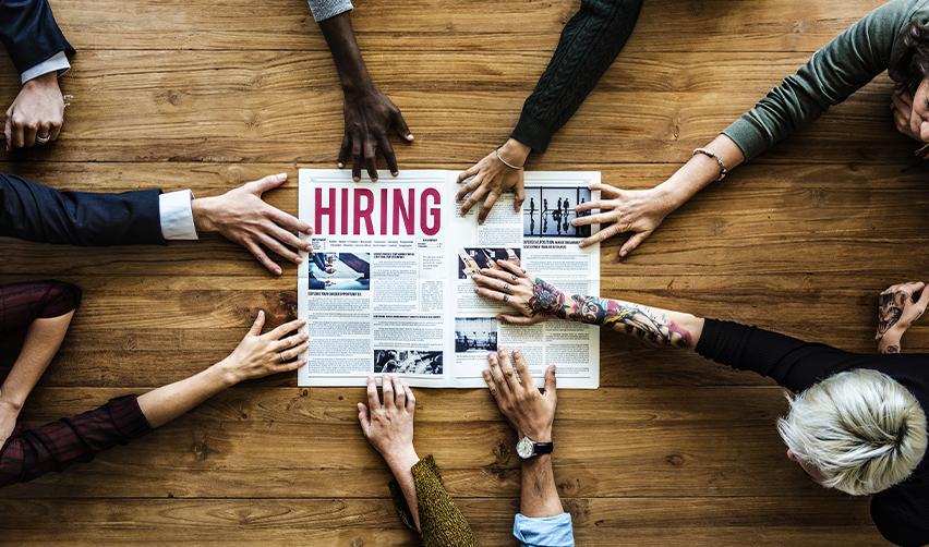 A group of people reaching out for a job post, symbolizing EB5 job creation.
