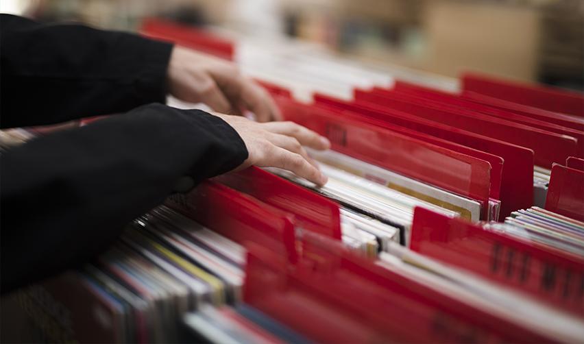 A national visa center officer's hands searching through a stack of files and documents.
