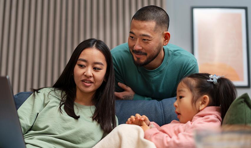 A family of EB5 investors looking at a laptop screen to access the United States citizenship and immigration services website.
