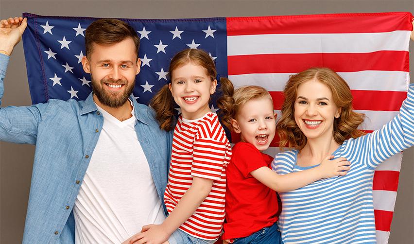 A family of EB5 investors holding the American flag up.