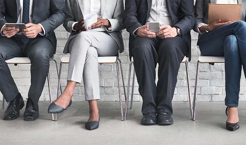 A cropped image of a group of foreign investors, foreign workers or lottery system applicants sitting at a waiting room to obtain a work visa.