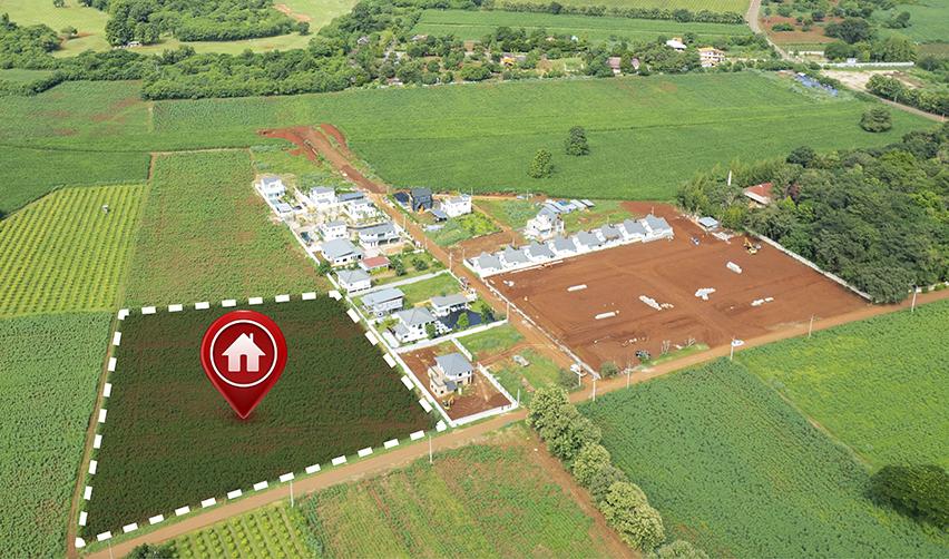 A plot of land with a pin dropped on it. There's a digital house icon inside the pin.