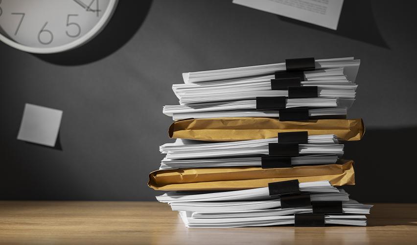 A stack of source of funds documentation on an office desk.