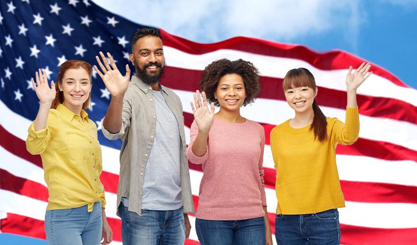 Some foreign investors waving at the camera in front of the U.S. flag.
