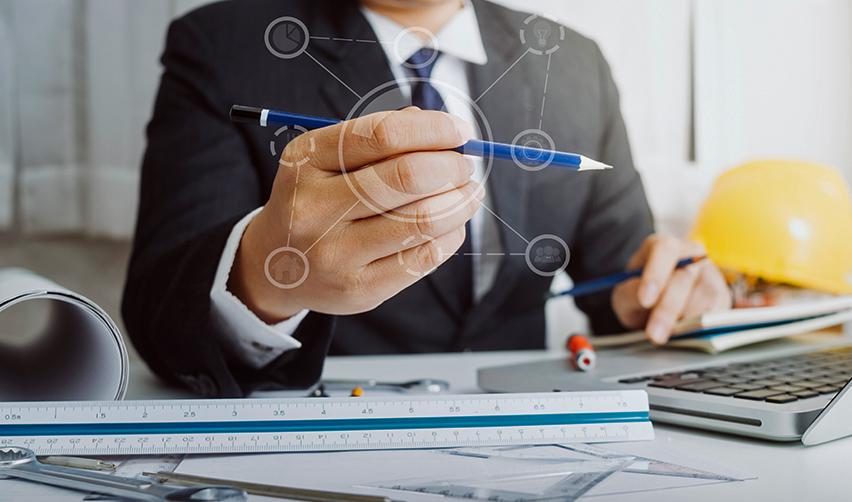 An EB5 project developer holding a pencil and working at an office.