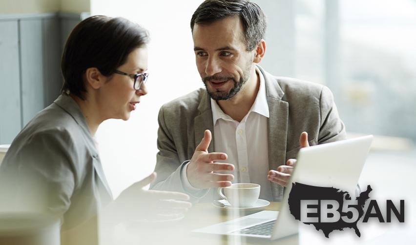 An EB5 industry professional explaining the visa bulletin to an EB5 investor at a regional center office, with the EB5AN logo on the corner.