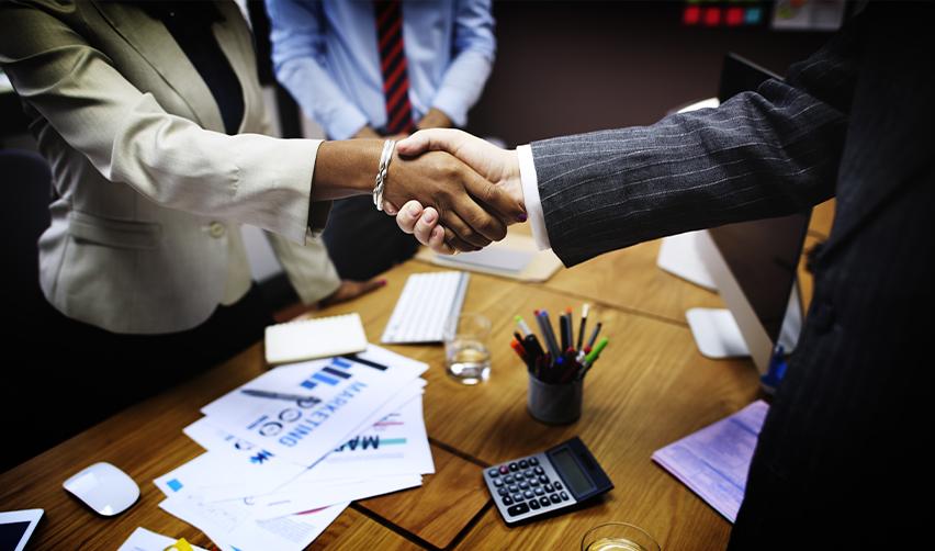 A foreign investor and a regional center managing partner shaking hands.