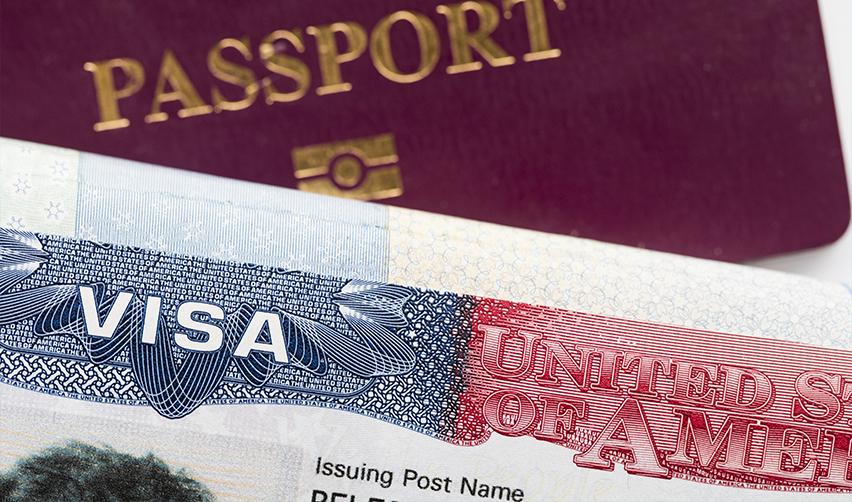 A close-up of a foreign investor's passport and a United States of America visa.