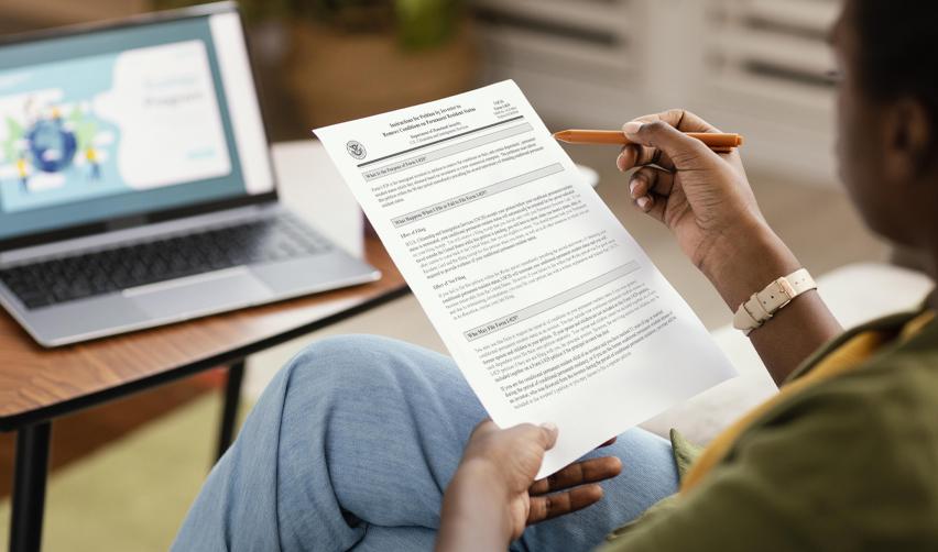 An EB5 investor going over an I-829 petition in front of a computer.
