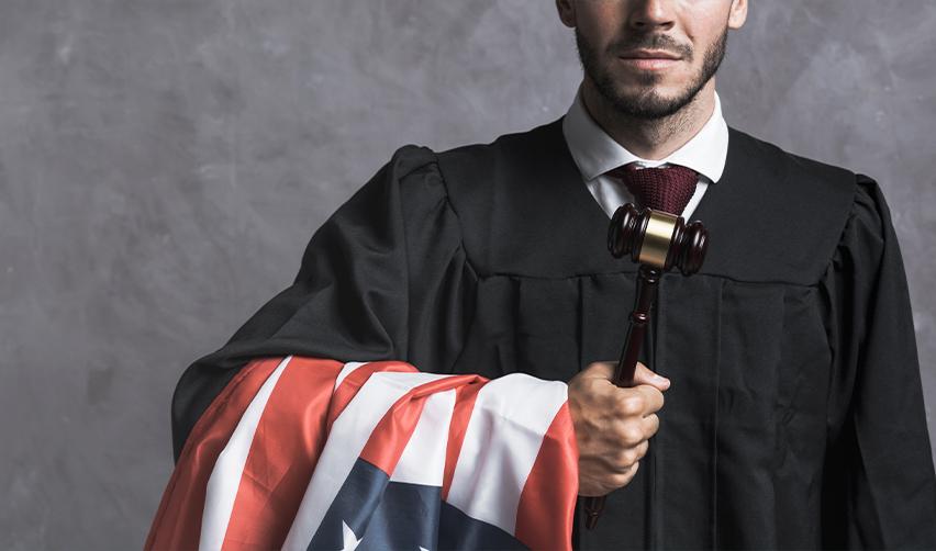 A judge holding a gavel and a U.S: flag in his hand, symbolizing EB5 legislation.