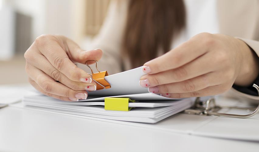 A person organizing some supporting documents for an EB5 visa, symbolizing the concurrent filing provision of the reform and integrity act of 2022.
