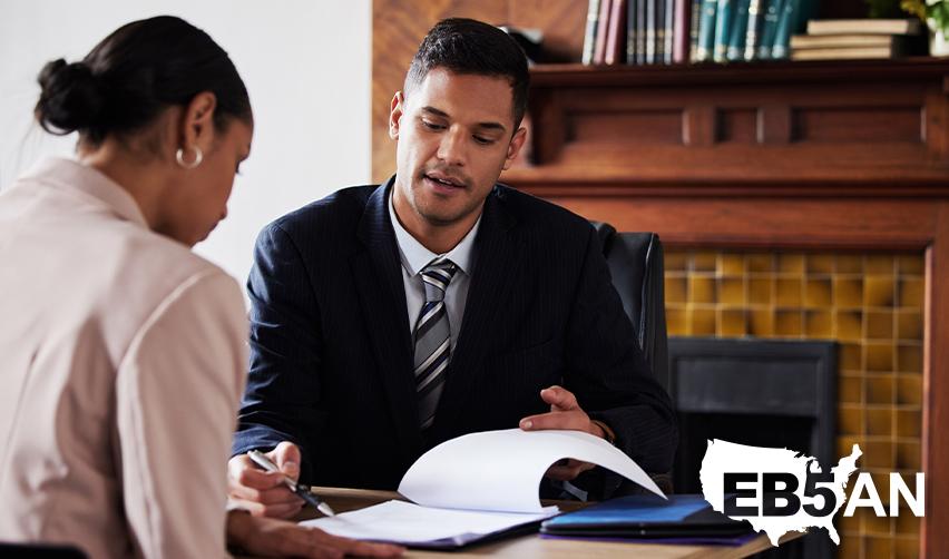 An EB5 immigration attorney showing a pre-ria eb5 investor her visa options on a document, with the EB5AN logo on the corner.