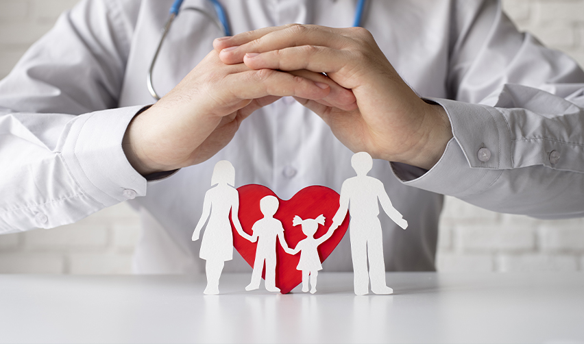 A doctor or healthcare professional shielding a paper cutout family with his hands, symbolizing U.S. healthcare access and safety for EB5 investors.
