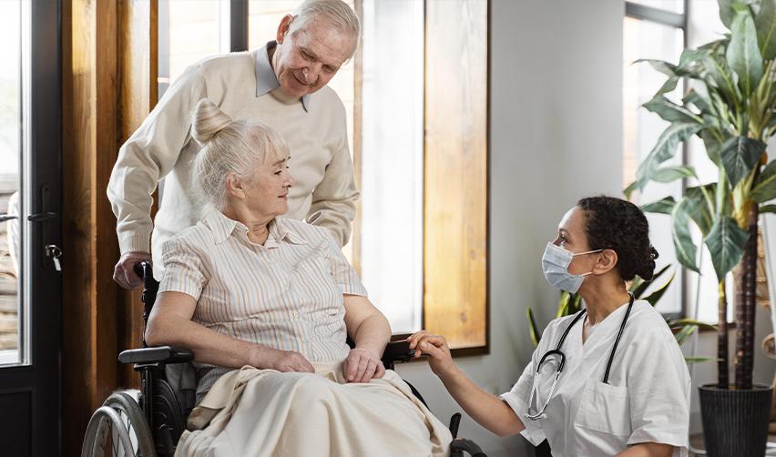 Elderly couple consulting a healthcare professional, highlighting the healthcare benefits available to Green Card holders through the EB5 program.