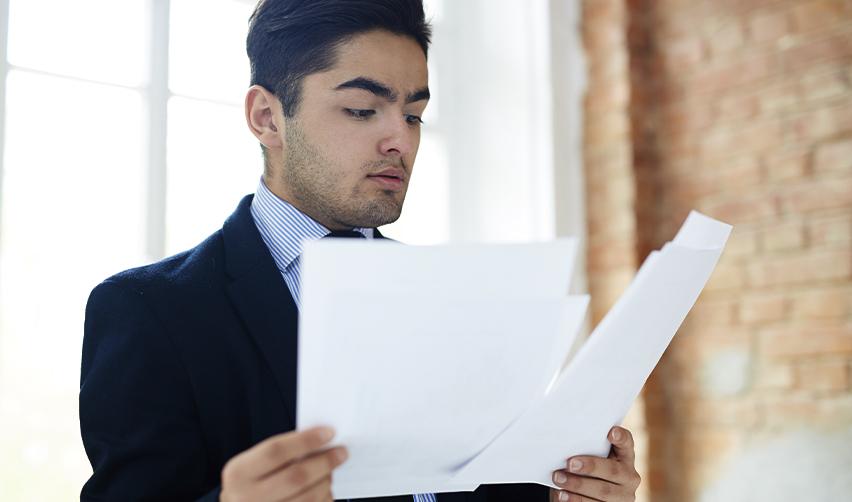 Businessman reviewing immigration documents, highlighting differences between NOIDs (Notices of Intent to Deny) and RFEs (Requests for Evidence) in the EB5 visa process.