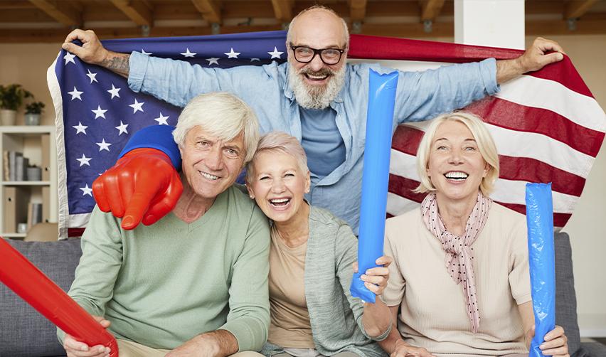 Group of retirees celebrating U.S. residency with an American flag, emphasizing the benefits of the EB5 visa for Canadian retirees seeking a new life in the U.S.