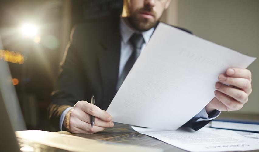 Professional reviewing USCIS forms at a desk, representing the importance of staying prepared for RFEs and NOIDs in the EB5 visa process.