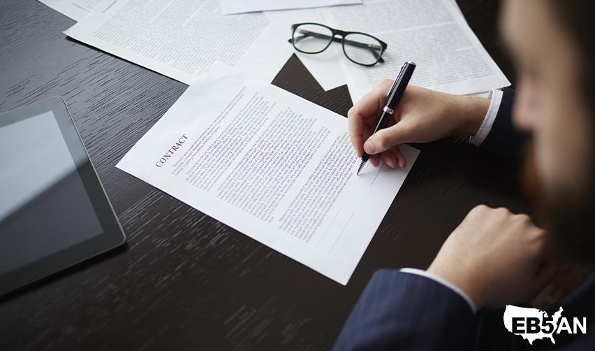 An EB5 investor signing some contract documents related to their rural TEA investment for fast green card processing, above the EB5AN logo.