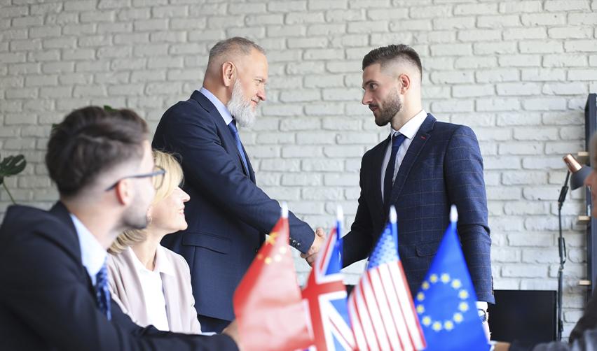 EB1c multinational company employees shaking hands.
