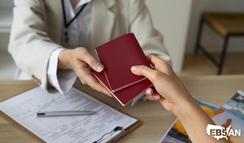 Close-up of a professional handing over a passport, symbolizing the visa application process for Eb5 visas, with the EB5AN logo on the corner.