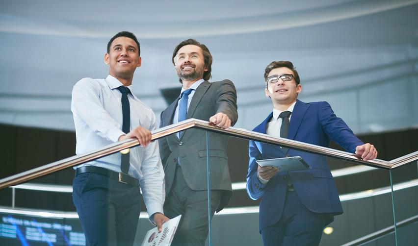 A diverse group of professionals confidently standing in an office, symbolizing the flexibility and independence gained through the EB5 visa program.