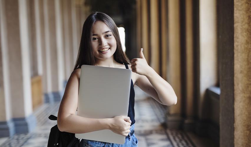 smiling STEM student giving a thumbs-up, highlighting the benefits of switching from an F1 visa to an EB5 visa for career and residency opportunities.
