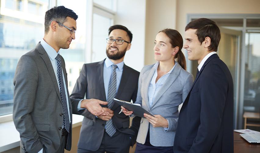Group of business professionals networking and discussing EB5 project strategies, showcasing the importance of staying connected with EB5 industry leaders.