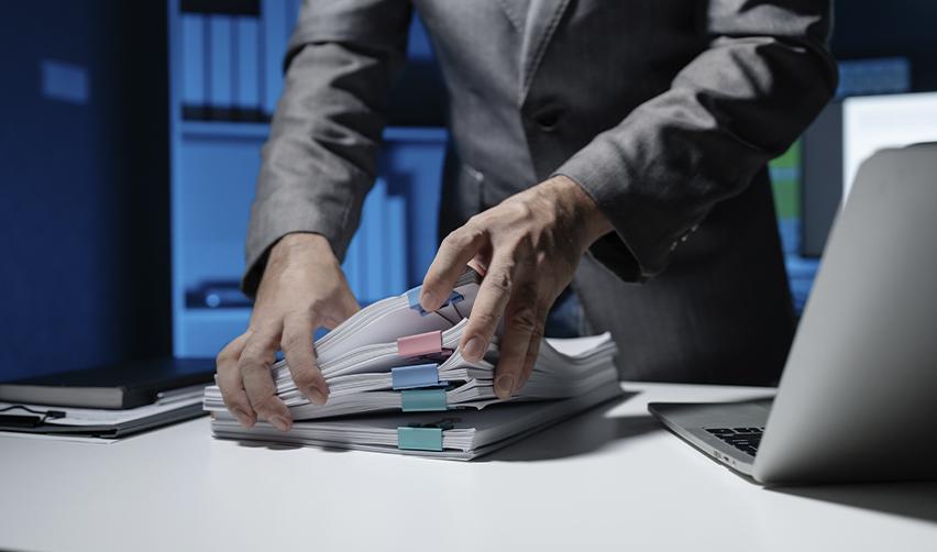 A person sorting through EB5 visa application documents, highlighting the importance of organized documentation for a successful visa process.