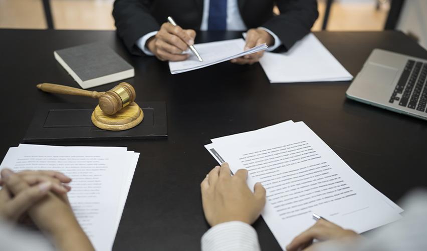 Legal professionals at a desk with official documents and a gavel, illustrating the process of filing a motion or appealing an EB5 petition denial.