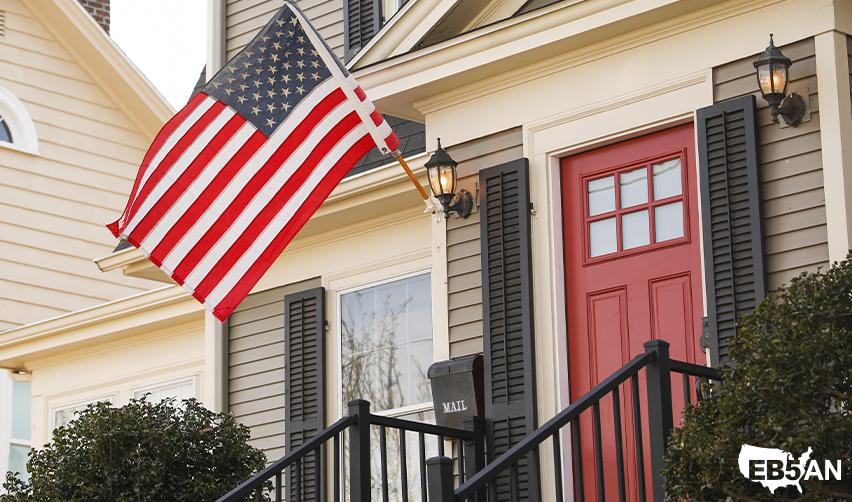 The EB5AN logo and an American flag displayed on a residential house, symbolizing the journey to US citizenship through the EB5 visa program.