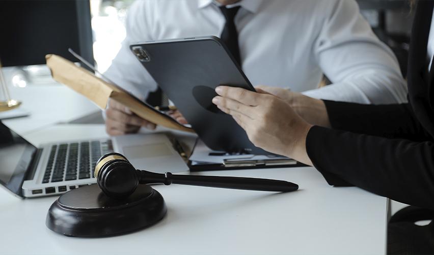 Close-up of a gavel with immigration attorneys reviewing supporting documents, highlighting regulatory compliance and legal expertise for EB5 investors.