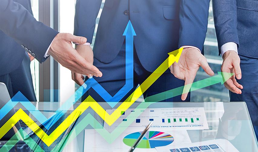 A group of business professionals discussing financial growth strategies with a focus on EB5 investments. The table displays charts and graphs indicating upward trends, symbolizing successful investment opportunities in EB5 regional center projects.