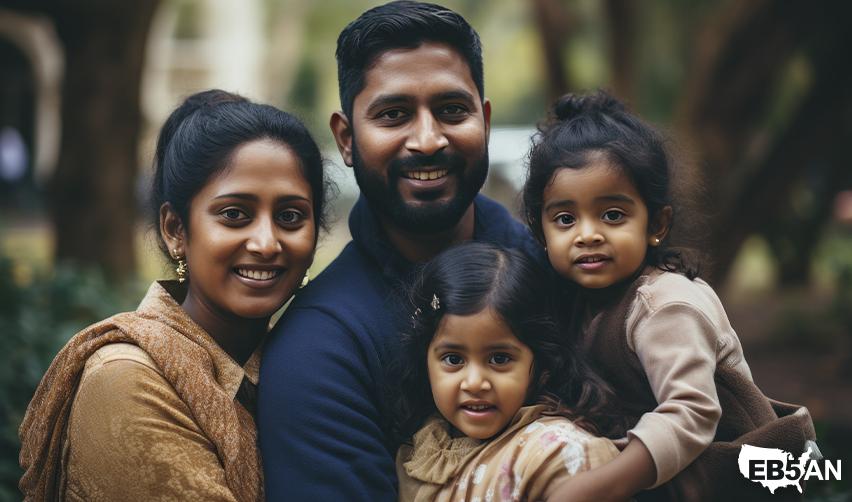 Smiling Indian family of four outdoors, representing families benefiting from U.S. immigration options like the EB5 visa, next to the EB5AN logo.