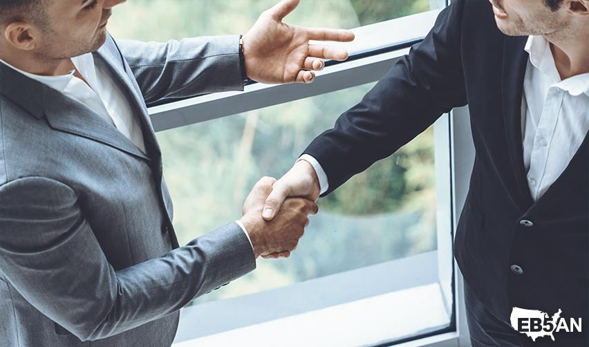 An EB5 investor shaking hands with a regional center team member, symbolizing collaboration and partnership in navigating EB5 visa processes with EB5AN.
