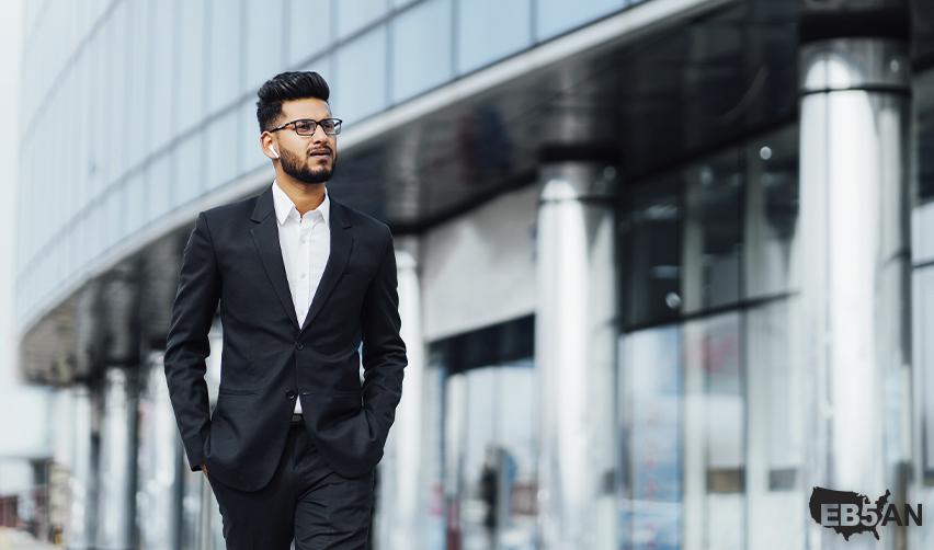 The EB5AN logo next to a professional businessman walking outside a modern office building, representing career opportunities for EB5 investors in America.