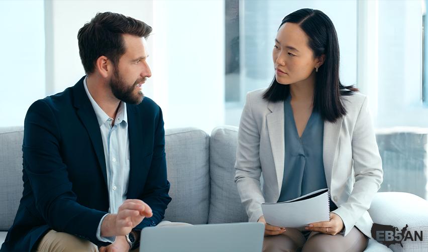 The Eb5AN logo next to two professionals discussing EB5 visa investment options, emphasizing personalized consultation for securing a US Green Card in 2025.