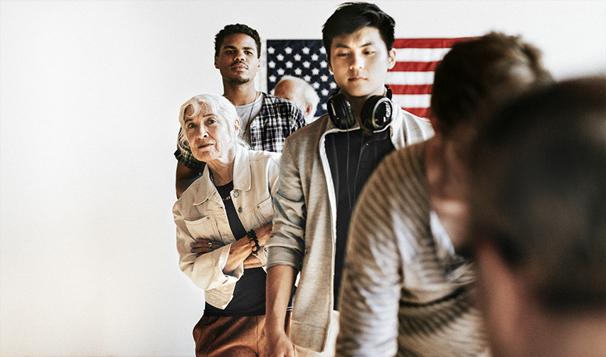 Immigrants waiting in line for U.S. visa processing with an American flag in the background—understanding EB5 visa eligibility and application steps.