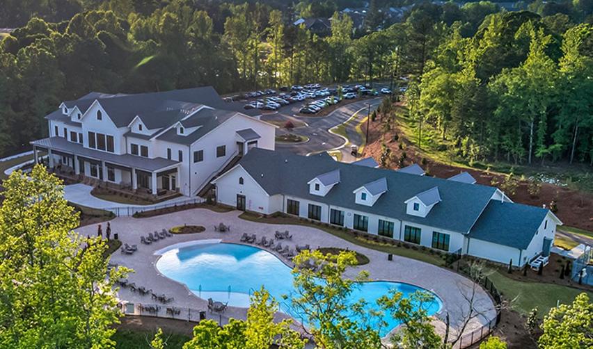 A concept image of the Twin Lakes EB5 project, sponsored by EB5AN, featuring a modern clubhouse and pool surrounded by lush greenery, showcasing the amenities of this active adult community.